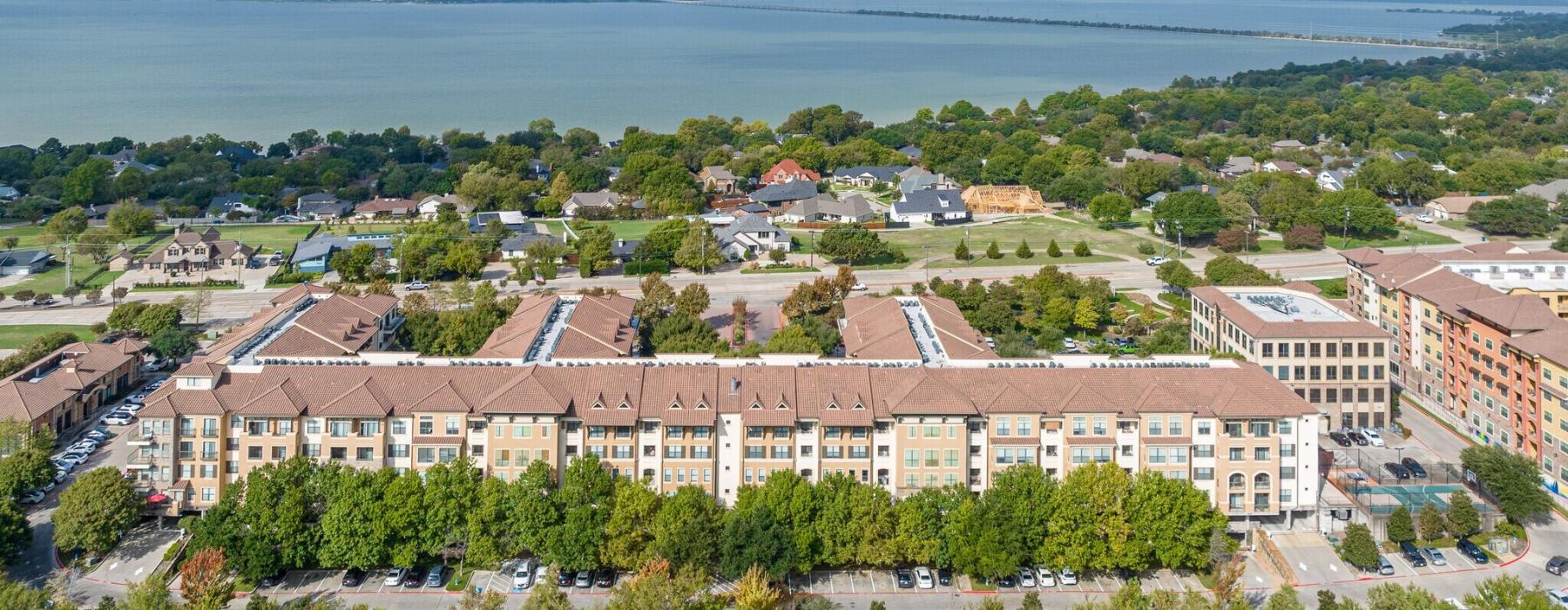 a large building with trees in front of it and a body of water in the background