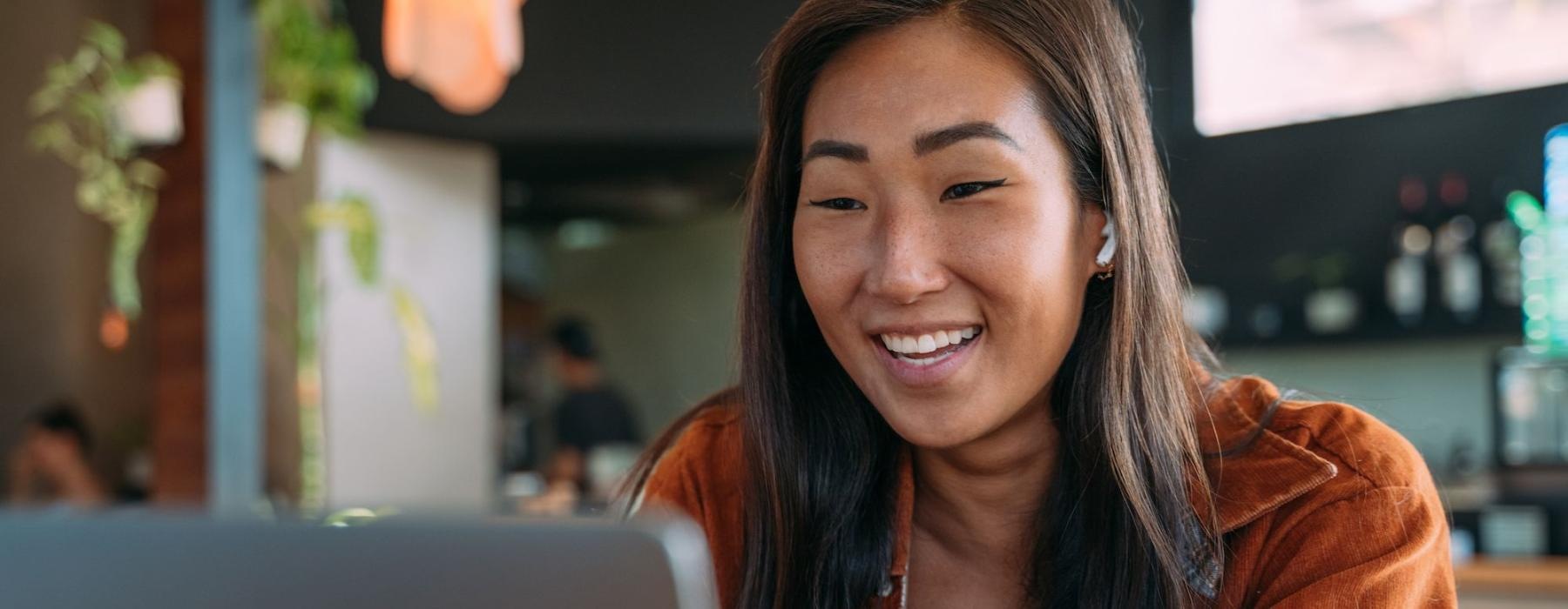 a woman smiling while working on laptop