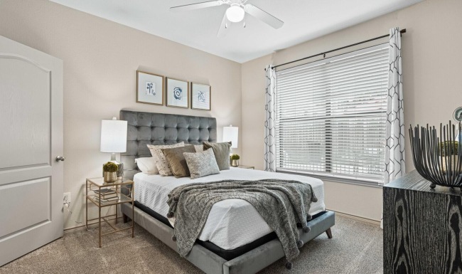 a bedroom with a bed and a fan